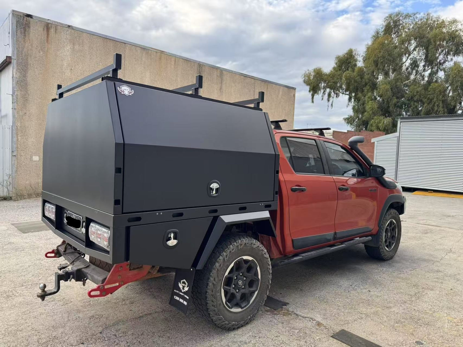 Red dual-cab ute with matte black canopy
